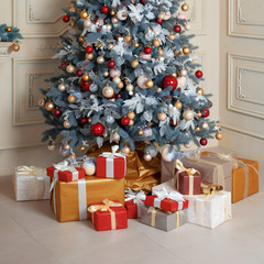 Beautiful holdiay decorated room with Christmas tree and presents under it. New Year decorations