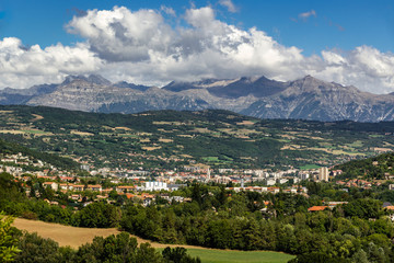 Fototapeta na wymiar The city of Gap in the Hautes Alpes with surrounding mountains and peaks in Summer. Southern French Alps, France
