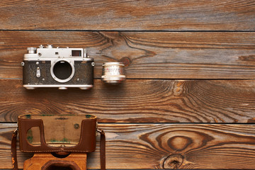 Fototapeta premium Vintage old camera and lens on wooden background