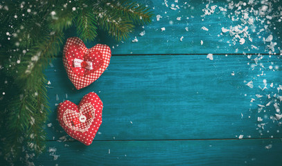 Christmas tree branch with snow and heart toy.