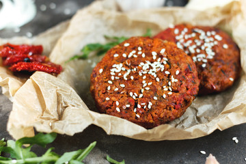 Potato burgers on baking paper om dark grey table. Still life of cooked batat burgers. Vegan food.  Close up.