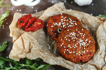 Potato burgers on baking paper om dark grey table. Still life of cooked batat burgers. Vegan food.  Close up.