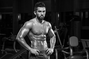 Fototapeta na wymiar Sexy muscular man posing in gym, shaped abdominal. Strong male torso abs, working out