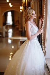 Naklejka premium beautiful young woman bride in luxury wedding dress in interior