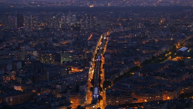 Spectacular top view of Paris at night in violet light with major road illuminated in orange. Wide panorama shot with the river the Seine in the background.