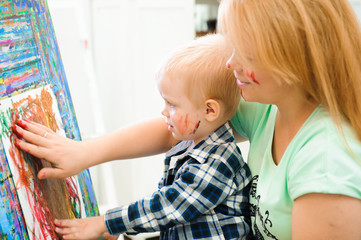 Obraz premium Mother and child draw a picture paints, art lesson
