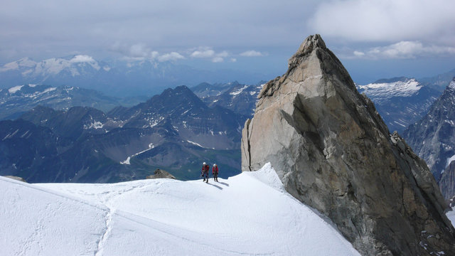 a mountain guide and client an an exposed ridge in the French Alps near Chamonix