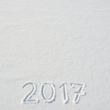 2017 numbers handwritten on flat snow surface. Empty space for copy, text, lettering. New year holiday postcard, greeting card template.