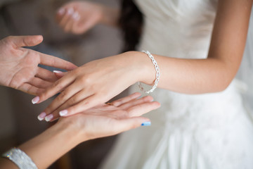 Obraz na płótnie Canvas Bride wrapping pearl bracelet on hand