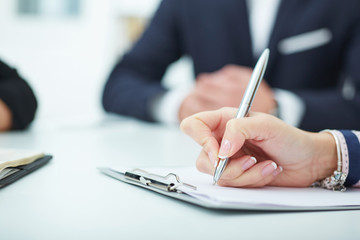 Female hands holding a silver pen closeup.  Business job offer, financial success, certified public...