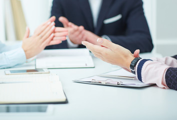 Photo of business partners hands applauding at meeting.