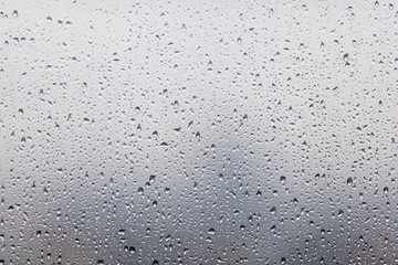 Rain drops on window glasses surface with cloudy background . Na