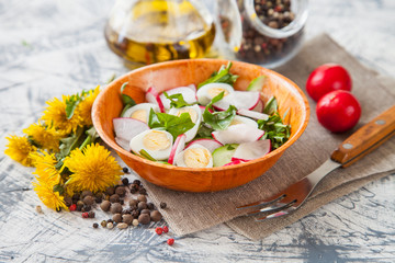 green salad with egg and dandelions in a bowl, selective focus