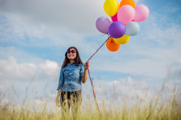 Fototapeta na wymiar Beautiful Girl jumping with balloons on the beach