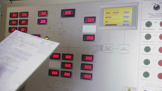 Industrial worker operating control paanel in control room of a industrial power factory. HD.