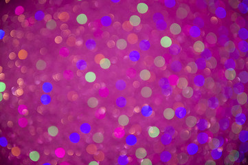 Holiday background in an abstract defocus in vibrant magenta pink bokeh with spots of other colors