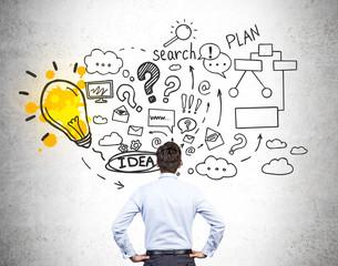 Businessman in blue shirt is looking at business plan sketch