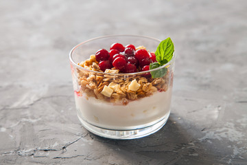 yogurt, muesli and berries in a glass on a table, selective focus