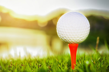 Close up of golf ball on tee against sunlight