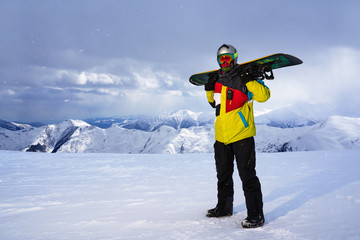 Fototapeta na wymiar Snowboarder carries a snowboard in hand.