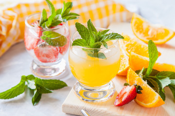 drinks with strawberry and orange in a glass on a table, selective focus