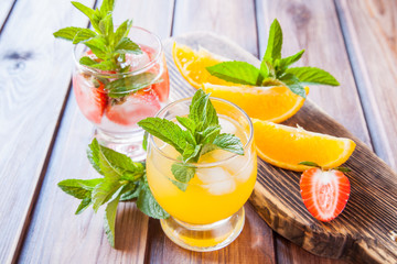 drinks with strawberry and orange in a glass on a table, selective focus
