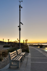 Fototapeta na wymiar Pedestrian resting benches along Ventura Boardwalk at sunrise.