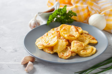 potatoes baked by slices in a plate on a table, selective focus