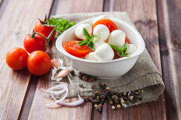 caprese salad: tomato, mozzarella and basil leaves, selective focus