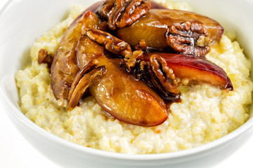 Rice pudding with plums and nuts. Frying plums