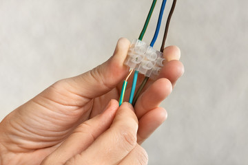 hands connecting wires in terminal block