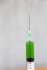 Green liquid medicine in the syringe.