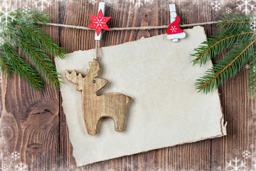 Christmas card with old paper sheet, deer toy and fir branches, snow frame