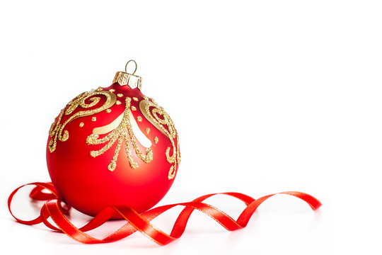 Christmas ball with golden ornament and red ribbon, beautiful holiday decoration. Christmas and New Year's Day wallpaper, greeting card.
