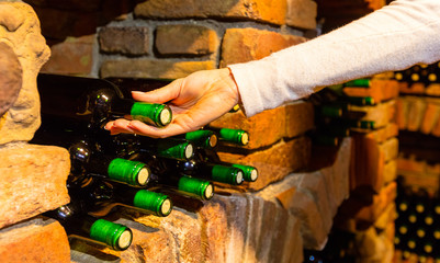 Woman hand taking bottle of wine