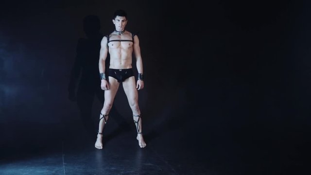 Sexy muscular man dance on dark background. Beautiful body. Sex and passion. Copy space text. Professional color correction.