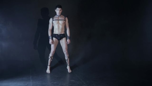 Sexy muscular man dance on dark background. Beautiful body. Sex and passion. Copy space text. No color correction.