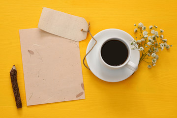 Obraz na płótnie Canvas Top view of cup of coffee next to blank paper