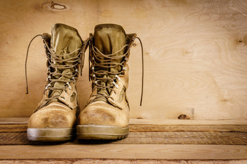 old brown military boots on a wooden table