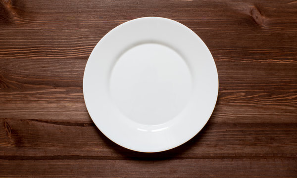 White round plate on a wooden background.