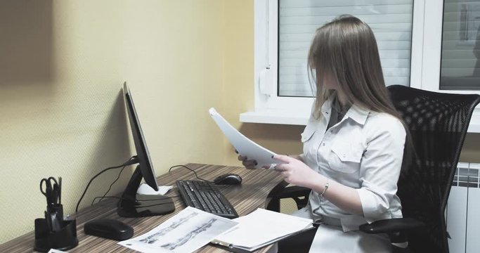Female doctor nurse working at computer with papers 4k video. Hospital clinic health care concept