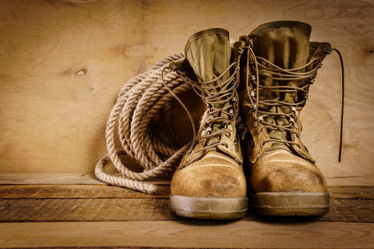 old military boots and rope on a wooden table
