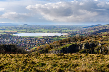 Cheddar Resevoir and the Somerset Levels from Cheddar Gorge. Bristol Water lake seen from high vantage point, with limestone cliffs of canyon in foreground
