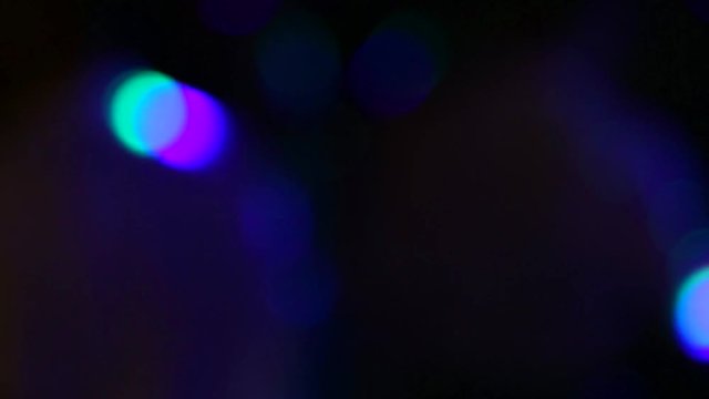 Beautiful flickering in darkness disco lights background. Changing bright blue, green, purple, red colors with flares. Real time full hd video footage