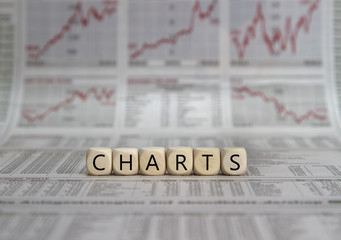 stock charts built with letter cubes on a newspaper background