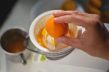 Closeup on hand of a person squeezing healthy orange juice mix