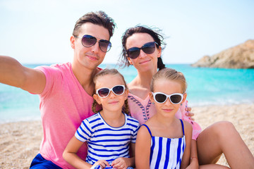 Obraz premium Young beautiful family taking selfie on the beach