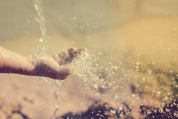 Close up of human hand catching water, ocean beach outdoors background