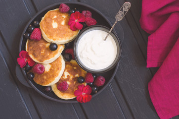 cheese pancakes with berries and yoghurt for breakfast