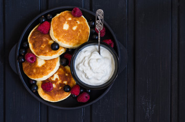cheese pancakes with berries and yoghurt for breakfast
